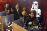 Seorang ibu menggunakan hak pilihnya di Tempat Pemungutan Suara (TPS) 05 yang memasang dekorasi berupa patung karakter tokoh film kartun Star Wars dan Smurf dalam Pilkada Serentak di Beji, Batu, Jawa Timur, Rabu (15/2). Dekorasi tersebut sengaja dipasang untuk menarik minat para pemilih agar datang ke TPS dan menggunakan hak pilihnya sekaligus mengurangi angka golput dalam Pilkada Serentak. Antara Jatim/Ari Bowo Sucipto/zk/17