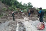 Anggota TNI Kodim 1304, Koramil Sumalata bersama masyarakat membersihkan material longsor yang menutupi badan jalan, yang menghubungkan kabupaten Gorontalo Provinsi Gorontalo dengan Kabupaten Buol, Provinsi Sulawesi Tengah.