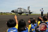 Sejumlah murid sekolah melambaikan tangan kepada pilot pesawat jet tempur Hawk 100/200 dari skuadron 12 Lanud Roesmin Nurjadin, Pekanbaru, seusai melakukan latihan 'Maverick' di Lanud Sultan iskandar Muda, Blang Bintang, Aceh Besar, Aceh, Jumat (24/2). Lanud Sultan Iskandar Muda memberikan kesempatan kepada sekitar seribuan murid sekolah untuk mengenal alutsista TNI AU serta memberikan pendidikan tentang sejarah keberadaan TNI-AU di tanah air.  (ANTARA Aceh/Ampelsa)