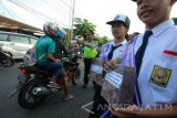 Sejumlah pelajar membentangkan spanduk berisi tentang keselamatan berlalu lintas saat sosialisasi keselamatan berlalu lintas di Surabaya, Jawa Timur, Jumat (24/2). Kegiatan tersebut guna memberikan pemahaman kepada pengguna jalan tentang pentingnya mematuhi peraturan lalu lintas dan keselamatan berlalu lintas. Antara Jatim/Didik Suhartono/zk/17