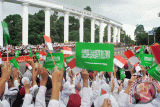 Sejumlah pelajar Kota Bogor mengibarkan bendera Merah Putih dan Arab Saudi saat kedatangan Raja Salman di Tepas Lawang Salapan, jalan Otista, Kota Bogor, Jawa Barat, Rabu (1/3). Raja Salman bersama delegasi Arab Saudi tiba di Istana Kepresidenan, Bogor untuk melakukan hubungan kerjasama bilateral dengan Presiden RI Joko Widodo. (ANTARA FOTO/Arif Firmansyah/17).