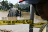 Warga mengamati jembatan Mrican pehubung Kota dengan Kabupaten Kediri yang roboh di Desa Jong Biru, Kediri, Jawa Timur, Kamis (2/3). Jembatan sepanjang 130 meter peninggalan kolonial Belanda tersebut roboh karena tidak kuat menahan derasnya arus sungai Brantas. Antara Jatim/Prasetia Fauzani/zk/17