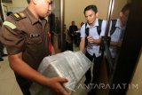 Petugas mengangkut sejumlah barang bukti kasus pungutan liar 'dwelling time' Pelabuhan Tanjung Perak ke dalam ruang Diversi Dan Tahap II, Kejaksaan Negeri (Kejari) Tanjung Perak Surabaya, Jawa Timur, Rabu (1/3). Tim penyidik Bareskrim Mabes Polri menyerahkan dua tersangka yaitu  R S (mantan Direktur Operasional dan Pengembangan Bisnis PT Pelindo III Persero) dan F F (Manajer PT Pelindo Energi Logistik), berkas dan sejumlah barang bukti kasus dugaan pungutan liar 'dwelling time' di Pelabuhan Tanjung Perak tersebut ke pihak Kejaksaan Negeri Tanjung Perak Surabaya. Antara Jatim/Didik Suhartono/zk/17