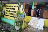 Seorang guru membersihkan sisa banjir yang sempat merendam SDN 01 Kademangan, Mojoagung, Jombang, Jawa Timur, Kamis (2/3). Sebanyak 11 sekolah yang ada di Kecamatan Mojoagung, Jombang, terpaksa meliburkan para siswanya karena banjir yang melanda kawasan tersebut. Antara Jatim/Syaiful Arif/zk/17