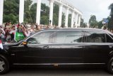 Raja Salman (kanan) tersenyum dari balik jendela mobilnya melihat pelajar dan warga Bogor menyambut kedatangannya di Tepas Lawang Salapan, jalan Otista, Kota Bogor, Jawa Barat, Rabu (1/3). Raja Salman bersama delegasi Arab Saudi tiba di Istana Kepresidenan Bogor untuk membicarakan kerjasama bilateral antara dua negara. ANTARA FOTO/Arif Firmansyah/pd/17
