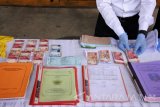 Petugas kepolisian menunjukkan barang bukti hasil Operasi Tangkap Tangan (OTT) pungli diluar uang sekolah di Mapolres Jember, Jawa Timur, Selasa (7/3). Tim Saber Pungli mengamankan tiga tersangka yang berprofesi sebagai kepala sekolah, dua wakil kepala sekolah SMKN 8 Jember dan sejumlah barang bukti seperti uang tunai Rp41.967.400 dari total Rp254 juta, kuitansi dan kartu ujian. Antara Jatim/Seno/zk/17