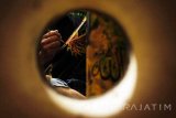 Komunitas seni lukis berbasis taruna desa 'b-friend' mengerjakan pesanan lukisan dengan media dasar potongan bambu di Kampung Majan, Tulungagung, Jawa Timur, Selasa (7/3).  Lukisan di atas media bambu itu dijual mulai Rp30 ribu hingga Rp50 ribu per buah dengan pemasaran terfokus ke Bali serta pasar online. Antara Jatim/Destyan Sujarwoko/zk/17