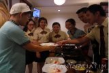 Seorang mahasiswa menyajikan masakan kepada pengunjung pada acara Gachi Hotel dan Restoran di Universitas Kristen Petra Surabaya, Kamis, (9/3). Acara bertema Korea tersebut digelar setiap tahun pada semester genap untuk menampilkan hasil karya para mahasiswa manajemen perhotelan. (Antara Jatim/Ria dan Nonik/SHP/17)
