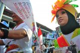 Seorang peserta karnaval Festival Pustaka Bergerak Surabaya 2017 membawa buku di Balai Kota Surabaya, Jawa Timur, Minggu (12/3). Pemerintah Kota Surabaya bekera sama dengan Gramdeia menggelar Festival Pustaka Bergerak Surabaya 2017 untuk meningkatkan minat baca masyarakat melalui kegiatan yang menarik. (Antara Jatim/Naufal Ammar/SHP/17)
