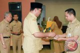 Bupati Hulu Sungai Tengah H. Abdul Latif serahkan Surat Keputusan (SK) pengangkatan Pegawai Negeri Sipil (PNS) kepada 106 orang CPNS yang sebelumnya termasuk dalam kategori II. Penyerahan itu dilakukan saat apel gabungan ASN di Halaman Kantor Bupati HST, Senin (13/3). Foto:Antaranews Kalsel/Upik/G. 