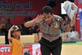 Seorang anggota polisi memberikan tata cara hormat yang baik dan benar kepada anak saat mengikuti sosialisasi aksi 123 Clear and Clean di Taman Rakyat Slawi, Kabupaten Tegal, Jawa Tengah, Minggu (12/3). Sosialisasi penerimaan anggota Polri 2017 tersebut mengajak masyarakat agar putra putri mereka mendaftar menjadi anggota Polri karena penerimaan anggota Polri itu tanpa calo dan bebas dari KKN. ANTARA FOTO/Oky Lukmansyah/aww/17.