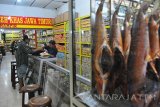 Pekerja melayani pelanggan di Toko Sudi Mampir, Jalan Genteng Besar, Surabaya, Jawa Timur, Selasa (14/3). Toko yang sudah berdiri sejak 1965 itu menjual berbagai makanan dan camilan khas Surabaya, mulai dari krupuk udang, krupuk ikan, krupuk kupang, rengginang lorjuk, sambal teri hingga bandeng asap. Antara Jatim/Naufal Ammar/Zk/17
