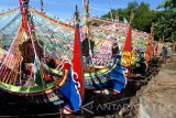 Nelayan menghias perahu untuk persiapan upacara petik laut di Pantai Desa Kaduara Timur, Sumenep, Jawa Timur, Selasa (14/3). Petik laut yang berlangsung dari tanggal 14-16 Maret tahun ini, melibatkan sedikitnya 50 perahu dihias dengan dana sekitar Rp200 juta yang dihasilkan secara mandiri oleh nelayan setempat. Antara Jatim/Saiful Bahri/zk/17