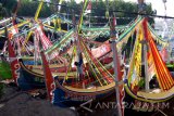 Nelayan menghias perahu untuk persiapan upacara petik laut di Pantai Desa Kaduara Timur, Sumenep, Jawa Timur, Selasa (14/3). Petik laut yang berlangsung dari tanggal 14-16 Maret tahun ini, melibatkan sedikitnya 50 perahu dihias dengan dana sekitar Rp200 juta yang dihasilkan secara mandiri oleh nelayan setempat. Antara Jatim/Saiful Bahri/zk/17