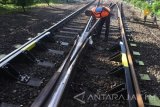 Pekerja melakukan perawatan rel kereta api di persimpangan jalur di Stasiun Geneng, Ngawi, Jawa Timur,  Selasa (14/3). Kementerian Perhubungan menargetkan jalur ganda kereta api lintas selatan jawa sepanjang lebih dari 400 kilometer akan tuntas dibangun pada tahun 2019 sebagai upaya untuk meningkatkan layanan serta menambah frekuensi kereta api. Antara Jatim/Ari Bowo Sucipto/zk/17.