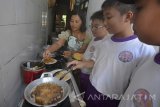 Sejumlah siswa Sekolah Dasar Kristen Benih Harapan menggoreng nugget saat eduwisata ikan lele di industri rumahan Aneka Olahan Lele Matrix, Sumbersari, Jember, Jawa Timur, Rabu (15/3). Eduwisata yang diikuti siswa kelas 1 sampai 6 tersebut untuk memberikan pengetahuan tentang budidaya ikan lele, aneka olahan berbagai macam panganan dari ikan lele, seperti nugget, stik duri, abon, pastel kering yang mengandung omega tiga, protein, kalsium sekaligus untuk kampanye membudayakan makan ikan.  Antara Jatim/Seno/zk/17. 