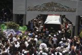 Santri dan pelayat mengantarkan mobil ambulan yang membawa jenazah KH Hasyim Muzadi di Pondok Pesantren Al Hikam, Cenggerayam, Malang, Jawa Timur, Kamis (16/3). Selanjutnya jenazah ulama yang pernah menjabat sebagai Ketua Umum PBNU tersebut diberangkatkan menuju Pondok Pesantren Al Hikam Depok untuk dimakamkan. Antara Jatim/Ari Bowo Sucipto/zk/17. 