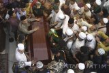 Santri dan pelayat berebut menggotong peti jenazah KH Hasyim Muzadi di Pondok Pesantren Al Hikam, Cenggerayam, Malang, Jawa Timur, Kamis (16/3). Selanjutnya jenazah ulama yang pernah menjabat sebagai Ketua Umum PBNU tersebut diberangkatkan menuju Pondok Pesantren Al Hikam Depok untuk dimakamkan. Antara Jatim/Ari Bowo Sucipto/zk/17. 