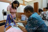 Petugas melakukan perekaman data pemohon paspor di Kantor Imigrasi Klas II Blitar, Jawa Timur, Jumat (17/3). Guna mencegah upaya pengiriman TKI Nonprofesional ke luar negeri,Ditjen Imigrasi menerbitkan Surat Edaran Nomor IMI-0277.GR.02.06 tahun 2017 tentang Pencegahan Tenaga Kerja Indonesia Nonprofesional yang mengharuskan pemohon paspor baru di Indonesia, wajib memiliki deposito sebesar Rp 25 juta. Antara jatim/Irfan Anshori/zk/17