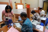 Petugas melakukan perekaman data pemohon paspor di Kantor Imigrasi Klas II Blitar, Jawa Timur, Jumat (17/3). Guna mencegah upaya pengiriman TKI Nonprofesional ke luar negeri,Ditjen Imigrasi menerbitkan Surat Edaran Nomor IMI-0277.GR.02.06 tahun 2017 tentang Pencegahan Tenaga Kerja Indonesia Nonprofesional yang mengharuskan pemohon paspor baru di Indonesia, wajib memiliki deposito sebesar Rp 25 juta. Antara jatim/Irfan Anshori/zk/17