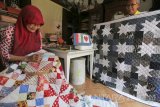 Perajin membuat tutup kasur (bed cover) di Surabaya, Jawa Timur, Rabu (15/3). Kerajinan dompet anak kunci, gantungan kunci, sarung bantal, tutup kasur (bed cover), hiasan dinding dan tas berbahan dari kain perca tersebut dijual dengan harga Rp45.000 sampai Rp4.500.000 tergantung bentuk dan tingkat kesulitannya. Antara Jatim/Didik Suhartono/zk/17 