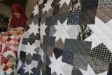 Perajin membuat tutup kasur (bed cover) di Surabaya, Jawa Timur, Rabu (15/3). Kerajinan dompet anak kunci, gantungan kunci, sarung bantal, tutup kasur (bed cover), hiasan dinding dan tas berbahan dari kain perca tersebut dijual dengan harga Rp45.000 sampai Rp4.500.000 tergantung bentuk dan tingkat kesulitannya. Antara Jatim/Didik Suhartono/zk/17 