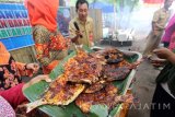 Sejumlah warga pesisir mengikuti pelatihan pembuatan kuliner ikan bakar di Pantai Pulau Santen, Banyuwangi, Jawa Timur, Senin (20/3). Pelatihan kuliner oleh Dinas Perikanan tersebut bertujuan untuk memberdayakan masyarakat sekitar agar ikut serta dalam mengembangkan sektor pariwisata. Antara Jatim/Budi Candra Setya/zk/17.