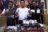 Polisi menunjukkan barang bukti rokok ilegal dengan pita cukai palsu dan barang bukti lainnya saat gelar perkara di Polresta Sidoarjo, Jawa Timur, Senin (20/3). Satreskrim Polresta Sidoarjo berhasil mengamankan tersangka yang setiap dua minggu bisa memproduksi sebanyak 10-15 ball yang 1 ball berisi 20 press rokok dengan segalaa merk. Antara Jatim/Umarul Faruq/zk/17