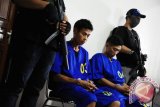 Dua dari empat tersangka pelaku penyelundupan sabu dari Malaysia dikawal petugas saat mengikuti rilis kasus yang digelar Badan Narkotika Nasional (BNN) di Kantor BNN Kalbar, Selasa (21/3). Pada Senin (20/3), Tim gabungan dari BNN, TNI, Polri dan Bea Cukai berhasil menggagalkan penyelundupan sebelas kilogram sabu dari Malaysia serta membekuk tiga pelaku asal Kabupaten Sanggau, Kalbar berinisial Wh, Gd dan Gm, dan menembak mati satu pelaku yaitu Apoh karena melakukan perlawanan saat hendak ditangkap. ANTARA FOTO/Jessica Helena Wuysang/17