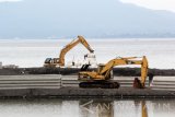 Alat berat beroperasi menyelesaikan pembangunan dermaga kapal pesiar di pantai Boom, Banyuwangi,  Jawa Timur, Rabu (22/1). Pembangunan dermaga kapal pesiar itu direncanakan mampu menanpung 200 kapal pesiar, sehingga diharapkan dapat meningkatkan kunjungan wisatawan manca Negara. Antara Jatim/Budi Candra Setya/zk/17.