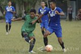 Pesepak bola Persepam Madura Utama (PMU) berusaha menghalangi pergerakan pesepakbola lokal (kiri) saat uji coba di Lapangan Kowel, Pamekasan, Jawa Timur, Rabu (22/3). Uji coba tersebut sebagai pesiapan pertandingan trofeo Persegres Gresik yang rencananya akan diikuti PMU, Perseru Serui dan Persegres sebagai tuan rumah dalam pekan ini. Antara Jatim/Saiful Bahri/zk/17