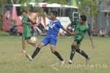 Pesepak bola Persepam Madura Utama (PMU) berusaha melewati pesepakbola lokal (kanan) saat uji coba di Lapangan Kowel, Pamekasan, Jawa Timur, Rabu (22/3). Uji coba tersebut sebagai pesiapan pertandingan trofeo Persegres Gresik yang rencananya akan diikuti PMU, Perseru Serui dan Persegres sebagai tuan rumah dalam pekan ini. Antara Jatim/Saiful Bahri/zk/17
