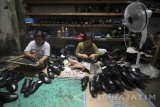 Pekerja menyelesaikan pembuatan sepatu berbahan kulit di industri rumahan sepatu kulit di Surabaya, Jawa Timur, Kamis (23/3). Menurut perajin, sepatu kulit yang dijual dengan harga mulai Rp100.000-Rp500.000 per pasang tersebut mengaku kesulitan untuk meningkatkan produksinya karena terkendala modal dan pemasaran. Antara Jatim/Moch Asim/zk/17 