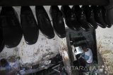 Pekerja menyelesaikan pembuatan sepatu berbahan kulit di industri rumahan sepatu kulit di Surabaya, Jawa Timur, Kamis (23/3). Menurut perajin, sepatu kulit yang dijual dengan harga mulai Rp100.000-Rp500.000 per pasang tersebut mengaku kesulitan untuk meningkatkan produksinya karena terkendala modal dan pemasaran. Antara Jatim/Moch Asim/zk/17 