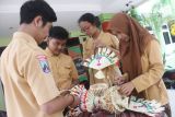 Pelajar dari berbagai agama membantu rekannya memasang dekorasi Nyepi di SMA Taman Harapan, Malang, Jawa Timur, Jumat (24/3). Kegiatan menyambut hari Raya Nyepi tersebut sengaja dilakukan para pelajar lintas agama sebagai bentuk solidaritas dan kerukuran antar umat beragama. Antara Jatim/Ari Bowo Sucipto/zk/17.