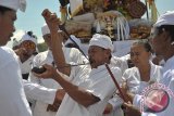 Seorang Umat Hindu yang kesurupan menusukkan keris ke mulutnya dalam upacara Melasti menjelang Hari Raya Nyepi Tahun Saka 1939 di Pantai Petitenget, Badung, Sabtu (25/3). Umat Hindu menggelar ritual Melasti secara serentak di seluruh kawasan pantai, danau dan sungai di Bali untuk penyucian diri dan alam semesta. ANTARA FOTO/Nyoman Budhiana/i018/2017.