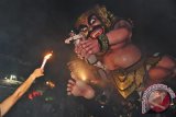 Para remaja mengarak Ogoh-Ogoh atau boneka raksasa yang melambangkan sifat buruk dalam parade Ogoh-Ogoh 2017 menjelang Hari Raya Nyepi Tahun Saka 1939 di Desa Tegallalang, Gianyar, Bali, Minggu (26/3). Arak-arakan Ogoh-Ogoh tersebut untuk menetralisir hal-hal negatif dan mengembalikannya ke asalnya sehingga Hari Raya Nyepi dapat dilaksanakan dengan penuh keheningan dan kedamaian. ANTARA FOTO/Nyoman Budhiana/i018/2017.