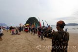 Umat Hindu berjalan di Pantai  saat melaksanakan upacara Melasti di Pulau Merah, Banyuwangi, Jawa Timur, Sabtu (25/3).  Upacara melasti yang dilaksanakan ribuan umat Hindu di Banyuwangi itu berlangsung hikmat. Antara Jatim/Budi Candra Setya/zk/17.