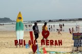 Sejumlah wisatawan menikmati suasana pantai Pulau Merah di Banyuwangi, Jawa Timur, Sabtu (25/3). Pulau merah merupakan salah satu wisata pantai unggulan di Banyuwangi yang banyak dikunjungi wisatawan lokal dan mancanegara karena keindahan pulau dan pasir putihnya. Antara Jatim/Budi Candra Setya/zk/17.