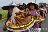 Sejumlah orang mengusung tumpeng saat mengikuti arak-arakan tumpeng di areal persawahan Desa Glinggang, Sampung, Ponorogo, Jawa Timur, Kamis (23/3). Kegiatan tersebut merupakan bagian dari rangkaian acara seni budaya Festival Desa Glinggang guna mengangkat kembali kearifan lokal daerah setempat. Antara Jatim/Foto/Siswowidodo/zk/17