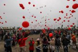 Instagramer  (pengguna instagram) melepas balon berwarna merah dan putih pada acara World Wide InstaMeet (WWIM) 15 Surabaya di Kawasan Bulak, Surabaya, Jawa Timur, Minggu (26/3). Sekitar seribu instagramer (pengguna instagram) bertemu dan mengabadikan setiap sudut Kampung Nelayan Warna Warni, Taman Suroboyo, Sentra Ikan Bulak dan Jembatan Suroboyo yang merupakan kawasan wisata pesisir pada acara tersebut. Antara Jatim/Didik Suhartono/zk/17