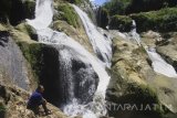 Wisatawan menikmati air terjun Tirto Galuh, Blitar, Jawa Timur, Selasa (28/3). Sejumlah warga memanfaatkan hari libur Nyepi dengan berekreasi di air terjun Titro Galuh-Blitar yang merupakan palung sungai. Antara Jatim/Ari Bowo Sucipto/zk/17. 