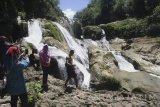 Wisatawan menikmati air terjun Tirto Galuh, Blitar, Jawa Timur, Selasa (28/3). Sejumlah warga memanfaatkan hari libur Nyepi dengan berekreasi di air terjun Titro Galuh-Blitar yang merupakan palung sungai. Antara Jatim/Ari Bowo Sucipto/zk/17. 