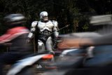 Seorang pengamen mengenakan kostum Robocop saat mengamen di kawasan Jalan Juanda, Depok, Jawa Barat, Kamis (30/3). Mengamen menggunakan kostum Robocop tersebut dilakukan Rusdi untuk menarik perhatian warga yang melintas. ANTARA FOTO/Indrianto Eko Suwarso/aww/17.