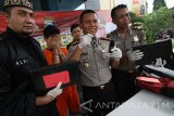 Kapolres Kediri AKBP Sumaryono (ke dua kanan) menunjukan barang bukti beserta tesangka pencuri playstation berinisial EP saat gelar perkara di Polres Kediri, Jawa Timur, Rabu (5/4). Tersangka yang merupakan karyawan di mini market berjaringan tersebut mengaku telah lima kali mencuri karena merasa gajinya terlalu kecil. Antara Jatim/Prasetia Fauzani/zk/17