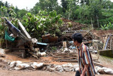 Seorang warga melintas di dekat rumah yang hancur akibat bencana longsor di Desa Banaran, Pulung, Ponorogo, Jawa Timur, Rabu (5/4). Tebing setinggi sekitar 70 meter yang longsor di wilayah tersebut Sabtu (1/4) menghancurkan 35 unit rumah warga dan menimbun 28 orang. Hingga hari kelima dari peristiwa tersebut baru tiga jenazah ditemukan dan belum ada kegiatan pembenahan rumah warga. Antara Jatim/Siswowidodo/zk/17