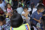 Relawan menghibur anak pengungsi korban longsor di posko penampungan pengungsi Desa Banaran, Ponorogo, Jawa Timur, Selasa (4/4). Terapi melalui skema trauma healing dilakukan relawan bencana untuk memulihkan psikologis anak pengungsi dari trauma bencana akibat kehilangan tempat tinggal serta orang tua mereka. Antara Jatim/Destyan Sujarwoko/zk/17