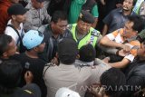 Polisi mengamankan seorang pemuda saat unjukrasa pedagang menolak relokasi pasar tradisional ke pasar terpadu di Merjosari, Malang, Jawa Timur, Kamis (6/4). Aksi yang diikuti ratusan pedagangtersebut berlangsung ricuh. ANTARA FOTO/Ari Bowo Sucipto/17.