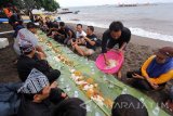 Sejumlah nelayan bersama Forum pimpinan daerah melakukan sukuran di pinggir Pantai Bangsring, Banyuwangi, Jawa Timur, Kamis (6/4). Untuk merayakan Hari Nelayan Nasional yang ke-57, Nelayan didaerah itu menggelar sukuran makan bersama dengan lauk ikan asin. Antara Jatim/Budi Candra Setya/zk/17.