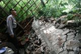 Seorang anggota Polisi memeriksa salah satu rumah yang terkena longsor di Desa Surat, Kecamatan Mojo, Kediri, Jawa Timur, Jumat (7/4). Longsor pasca hujan deras di wilayah lereng gunung Wilis tersebut mengakibatkan enam rumah warga rusak parah. Antara Jatim/Prasetia Fauzani/zk/17